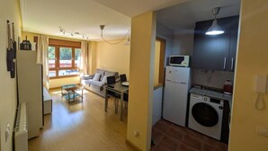 A compact living space with a dining area, sofa, and kitchenette. - 21A07 Apartment in Felechosa by R2R Consulting (Aller)