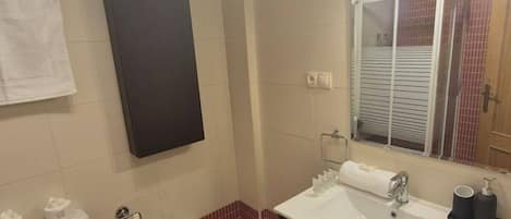 A bathroom with a white sink, a mirror, a towel rack, and a toilet.
