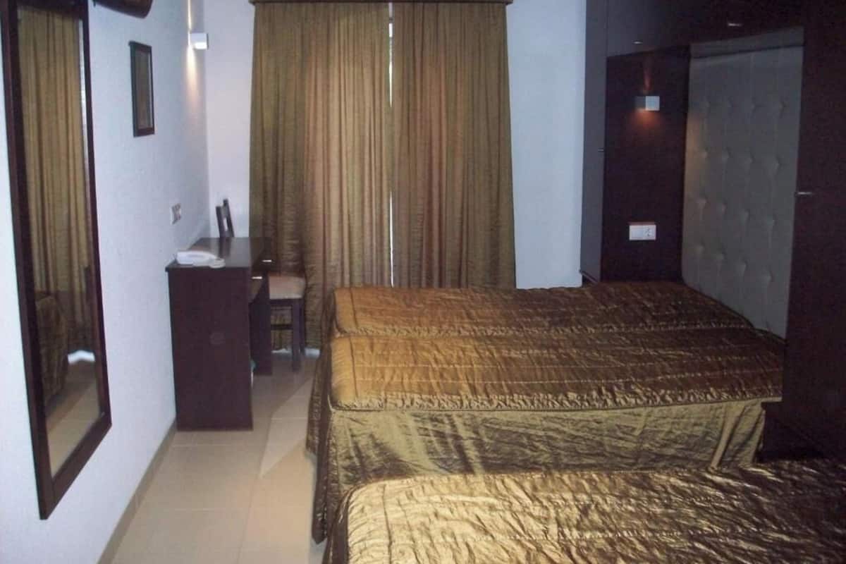 A hotel room with a bed, a desk, and a chair.