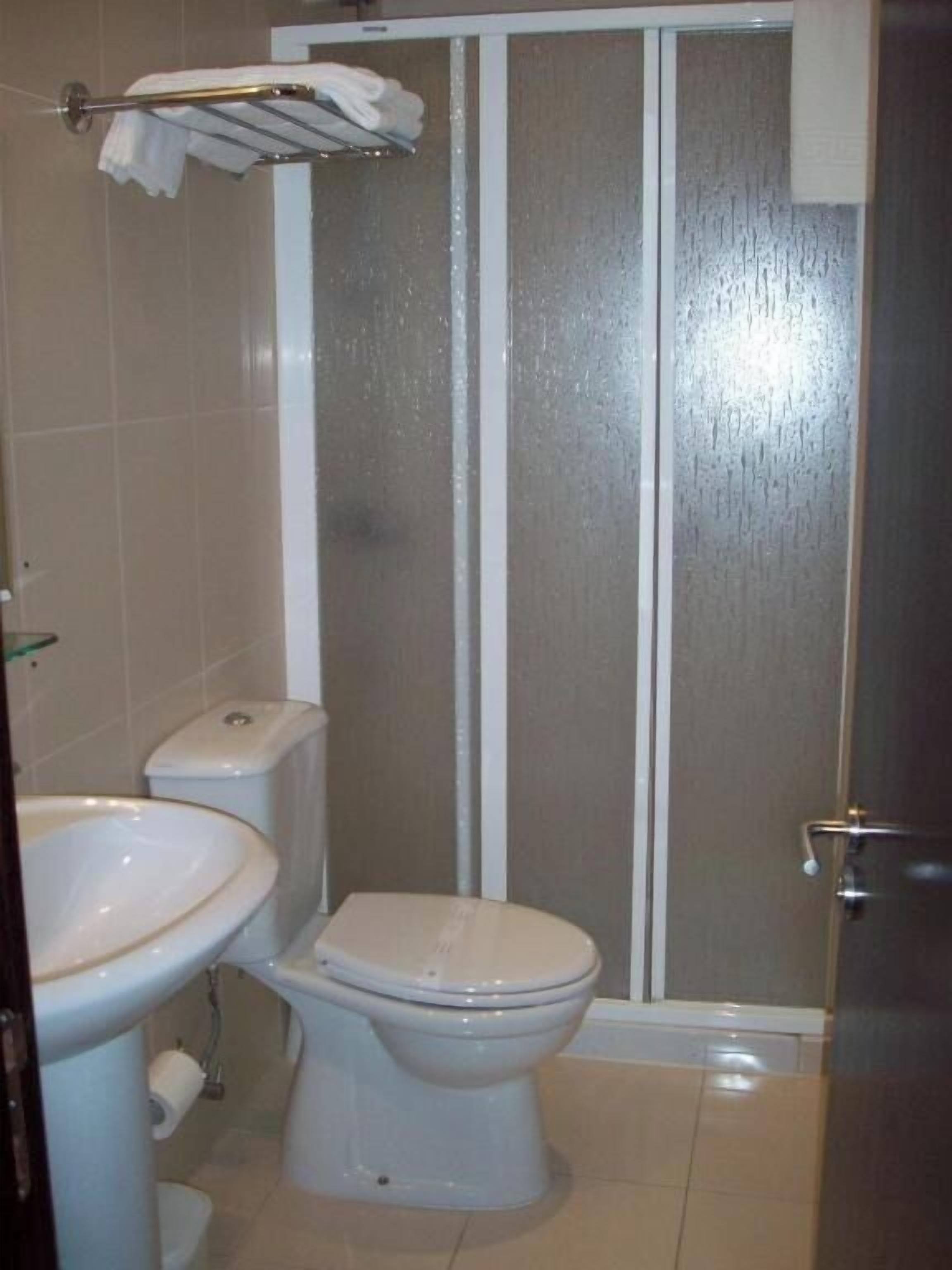 A bathroom with a toilet, bidet, and a shower enclosure.