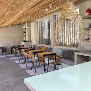 Ein modernes Interieur mit einem langen Esstisch, Stühlen und einer Pendelleuchte.