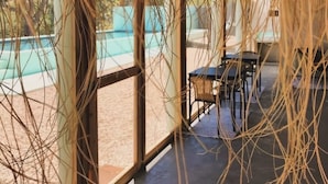 Un'area esterna coperta con una piscina sullo sfondo.