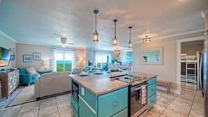 A spacious kitchen with a central island, modern appliances, and pendant lighting. - Awesome Beachfront | Gulf Views + Pools + Tennis + Pickleball & Beach Access (Port Aransas)