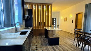 Een moderne keuken met een inbouwfornuis, een spoelbak en een houten wand met verticale lamellen.