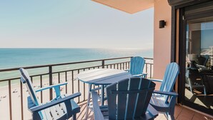 A balcony with a table and chairs overlooking the beach. - 1002E-Beautiful 2 bedroom and 2 bath newly remodeled unit (Orange Beach)