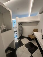 Un baño moderno con piso a cuadros, un tocador, un perchero y una decoración con forma de estrella.