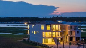 A multi-story building with a balcony, located near a body of water. - Summer Availability! Oceanfront w/ Pool (Ocean Isle Beach)