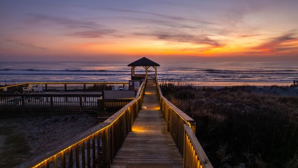 A wooden boardwalk leading to a beach area with a gazebo. - Oceanfront Pool & Spa, Volleyball Court, Game Rm (Corolla)