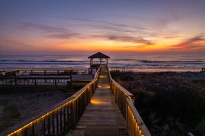 A wooden boardwalk leading to a beach area with a gazebo. - Oceanfront Pool & Spa, Volleyball Court, Game Rm (Corolla)