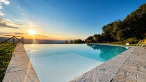 A clear sky, a swimming pool, and a sunset. - Private Tuscan farmhouse with infinity pool, panoramic view with 14 seats (Pelago)