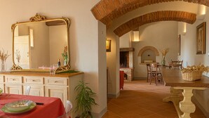 A dining area with a red tablecloth, clear chairs, a wooden bench, and a mirror with ornate gold framing. - Private Tuscan farmhouse with infinity pool, panoramic view with 14 seats (Pelago)