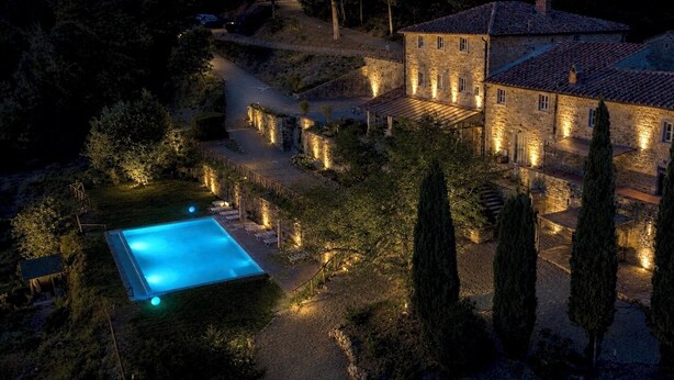 A stone building with a swimming pool, surrounded by trees and a well-lit pathway. - Private Tuscan farmhouse with infinity pool, panoramic view with 14 seats (Pelago)