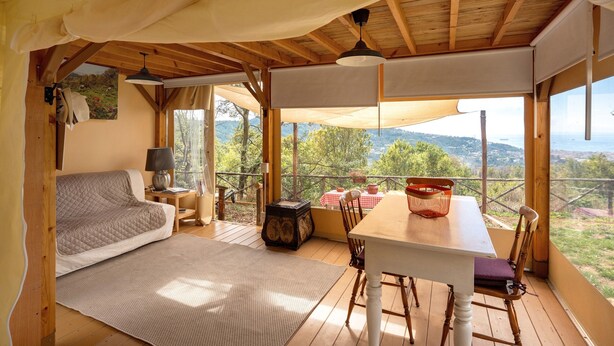 A cozy room with a bed, a table, and a view of the outdoors. - Ripa Garden: Panoramic Glamping between the Amalfi Coast and Cilento (Salerno)