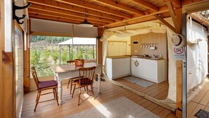 A wooden interior with a table and chairs, a kitchen area, and a view of the outdoors. - Ripa Garden: Panoramic Glamping between the Amalfi Coast and Cilento (Salerno)