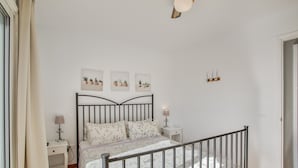 Ein Schlafzimmer mit Bett, Nachttischen, einer Lampe, Deckenleuchte und Wandbild.