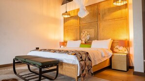 A bedroom with a bed, bedside lamps, a hanging canopy, and a wooden headboard. - Tabebuia Spa & Safari Resort (Fort Portal)