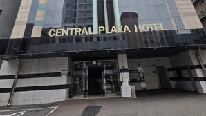The exterior of the Central Plaza Hotel, featuring a modern glass facade and a prominent entrance with a black and white striped awning. - Central Plaza Hotel (Suwon)