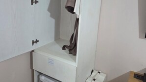 A compact room with a wardrobe, a small heater, and a desk. - Central Plaza Hotel (Suwon)