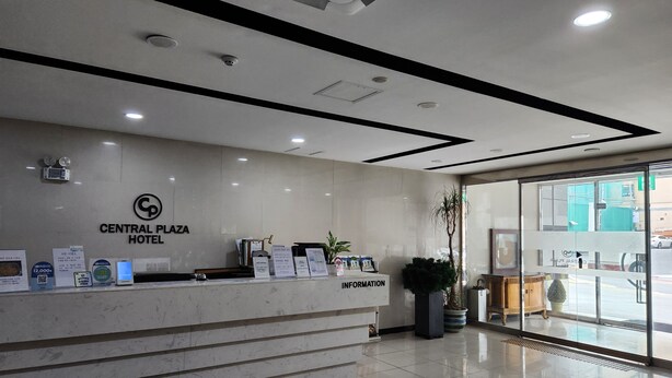 A hotel reception desk with a sign reading "Central Plaza Hotel". There are informational brochures and a digital display on the counter. - Central Plaza Hotel (Suwon)