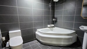 A modern bathroom with a bathtub, toilet, and sink. - Central Plaza Hotel (Suwon)