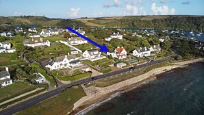 Eine Luftaufnahme einer Küstenstadt mit weißen Häusern, einer Straße und einem Strand.