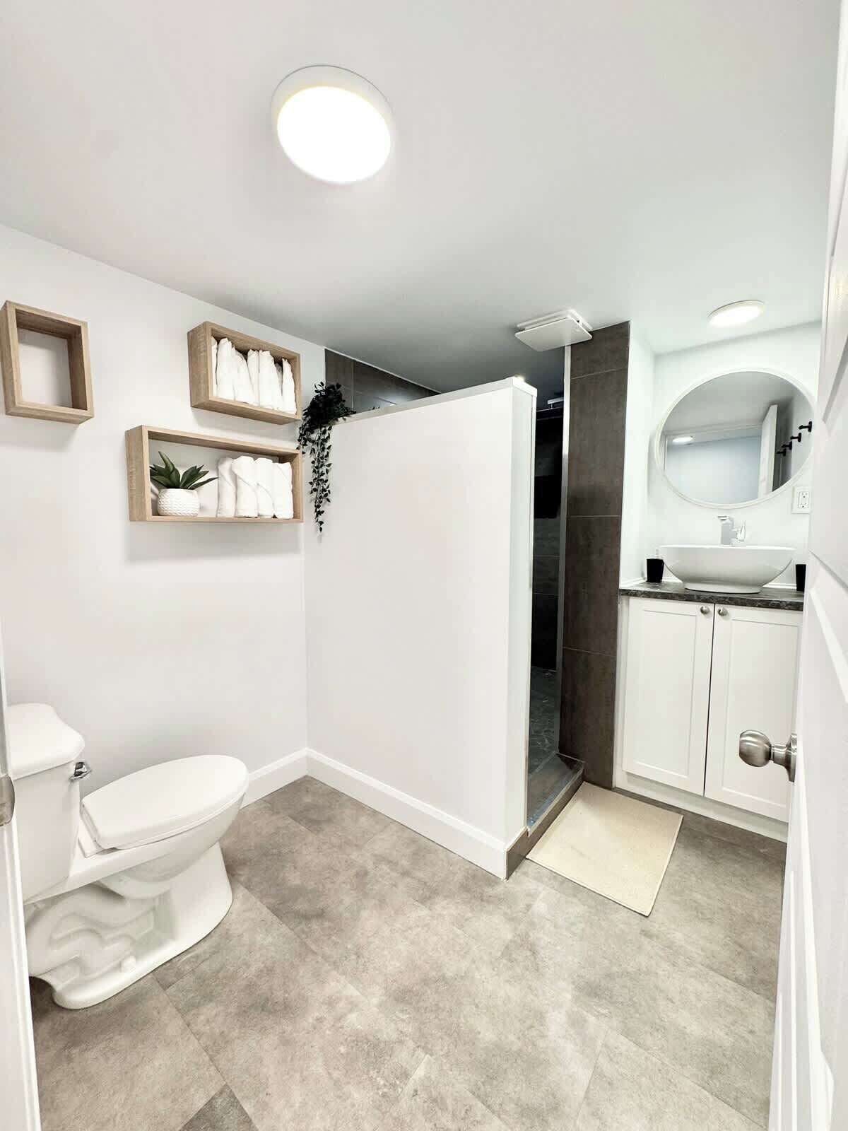 Un baño moderno con inodoro, ducha y lavamanos.