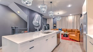 A modern kitchen with a central island, stainless steel appliances, and pendant lighting. - Lux Nash Escape•11 Beds•Hot Tub•Game Room + Pool+ Pickleball (Nashville)