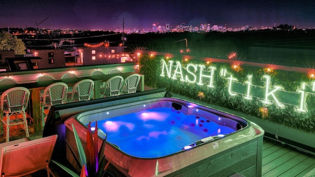 A rooftop terrace with a hot tub, chairs, and a neon sign reading "NASH TIKI". - Lux Nash Escape•11 Beds•Hot Tub•Game Room + Pool+ Pickleball (Nashville)