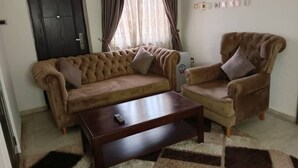 Un salon avec un canapé, un fauteuil et une table basse.