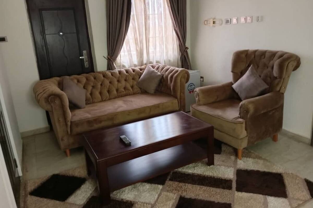 A living room with a sofa, armchair, and coffee table.