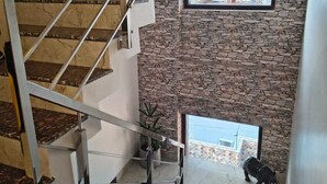 Una escalera moderna con un muro de piedra y vistas a la ciudad.
