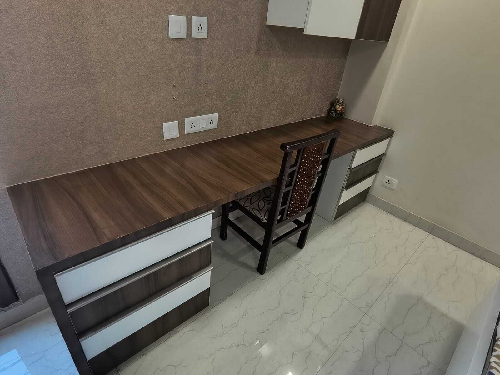 A modern kitchen with a dark wooden countertop, white drawers, and a marble backsplash.