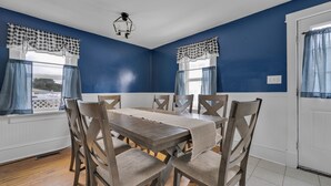 A dining room with a wooden table and chairs, blue walls, and checkered curtains. - 212 E. Savannah Road. Lewes, Delaware (Lewes)