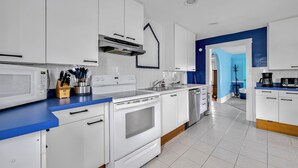 A modern kitchen with white cabinets, a blue countertop, and stainless steel appliances. - 212 E. Savannah Road. Lewes, Delaware (Lewes)