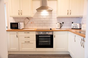 Fridge, microwave, toaster, dining tables - Bryn Bethel - sleeps 6 guests in 3 bedrooms (Caernarfon)