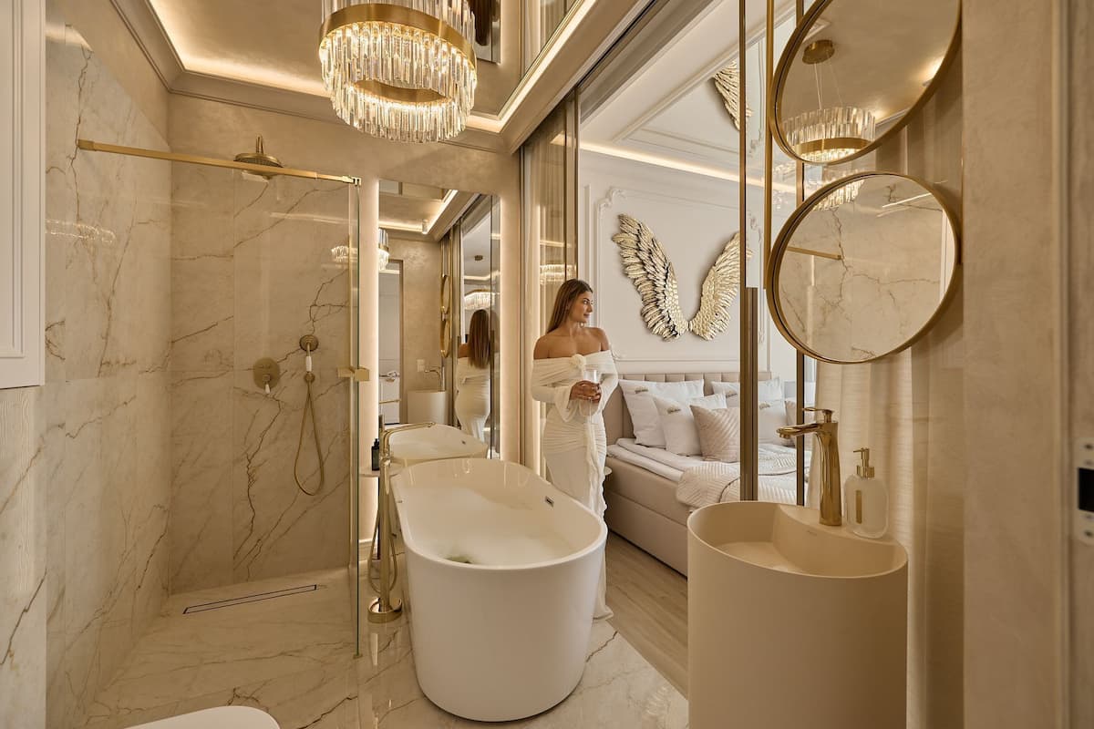 Un baño lujoso con una bañera independiente, un espejo grande y una zona de ducha.