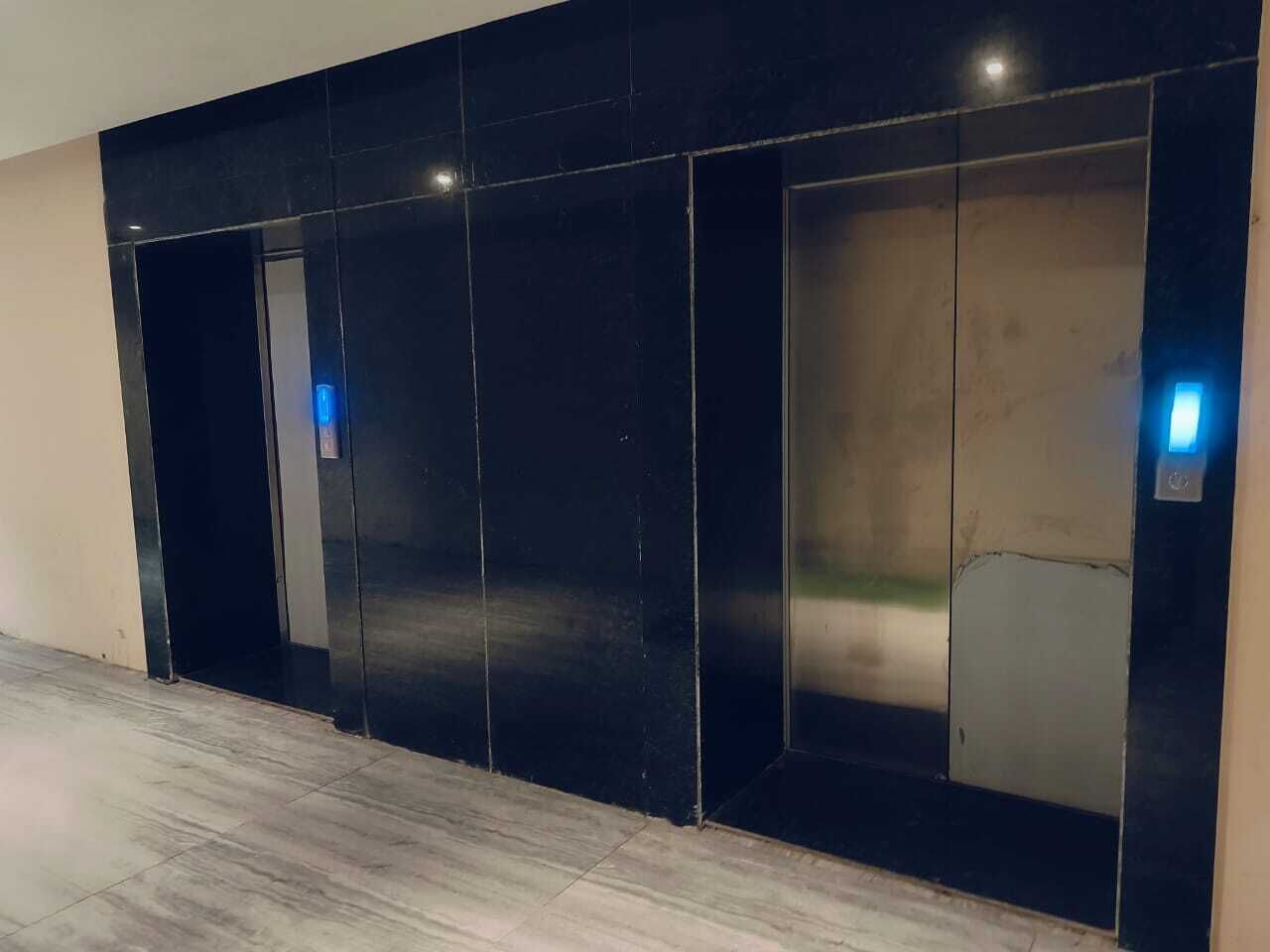 A modern elevator with a metallic finish and illuminated buttons.