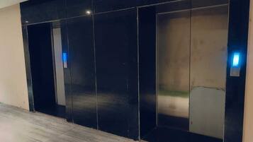A modern elevator with a metallic finish and illuminated buttons.