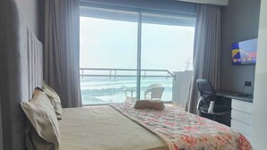 A hotel room with a bed, a desk, a chair, and a TV. - Luxury Stay Supernova (Noida)