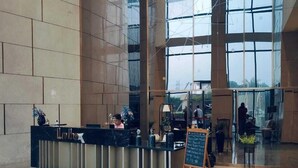 A spacious lobby with a reception desk, large windows, and a high ceiling. - Luxury Stay Supernova (Noida)