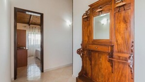 A hallway with a wooden cabinet and a mirror.
