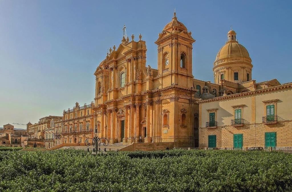 Un edificio histórico con una gran cúpula central y dos campanarios.