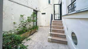 Un estrecho callejón con una escalera que lleva a la entrada de un edificio.