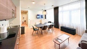 A modern apartment with a kitchen, dining area, and living room. It includes a dining table with chairs, a sofa, and a coffee table. - 138 - Urban Luxurious Flat in Saint Germain (París)