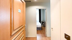 A hotel room with a wooden door marked with the number 138, a bed, a chair, and a small table. - 138 - Urban Luxurious Flat in Saint Germain (París)