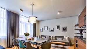 A modern living room with a dining area, a sofa set, and a kitchen area. - 138 - Urban Luxurious Flat in Saint Germain (París)