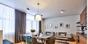 Una sala moderna con comedor, un conjunto de sofás y una zona de cocina.