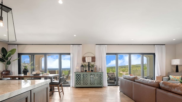 A spacious living area with a large sofa, dining table, and a view of the outdoors. - Villa Azulejos, Luxury villa with privacy and breathtaking views (Cabo San Lucas)