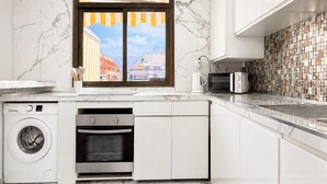 A modern kitchen with a built-in washer, oven, and microwave. - Luxury Penthouse Sunny Terrace by Alma Homes (Los Cristianos)