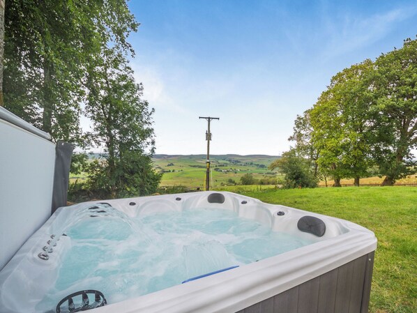 Un jacuzzi con vistas a un paisaje rural.
